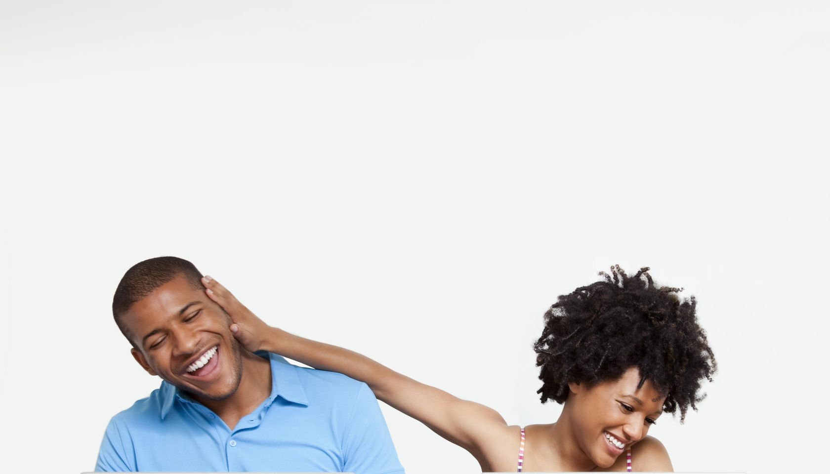 Woman joking with man as they work on laptops