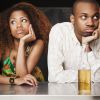 Couple sitting at bar and looking irritated