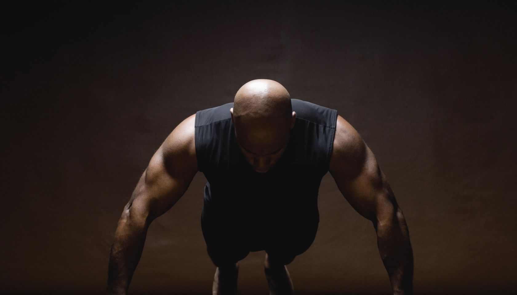 Man doing push-ups on dumbbells, studio shot
