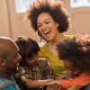 Cheerful African American parents and their small children at home.