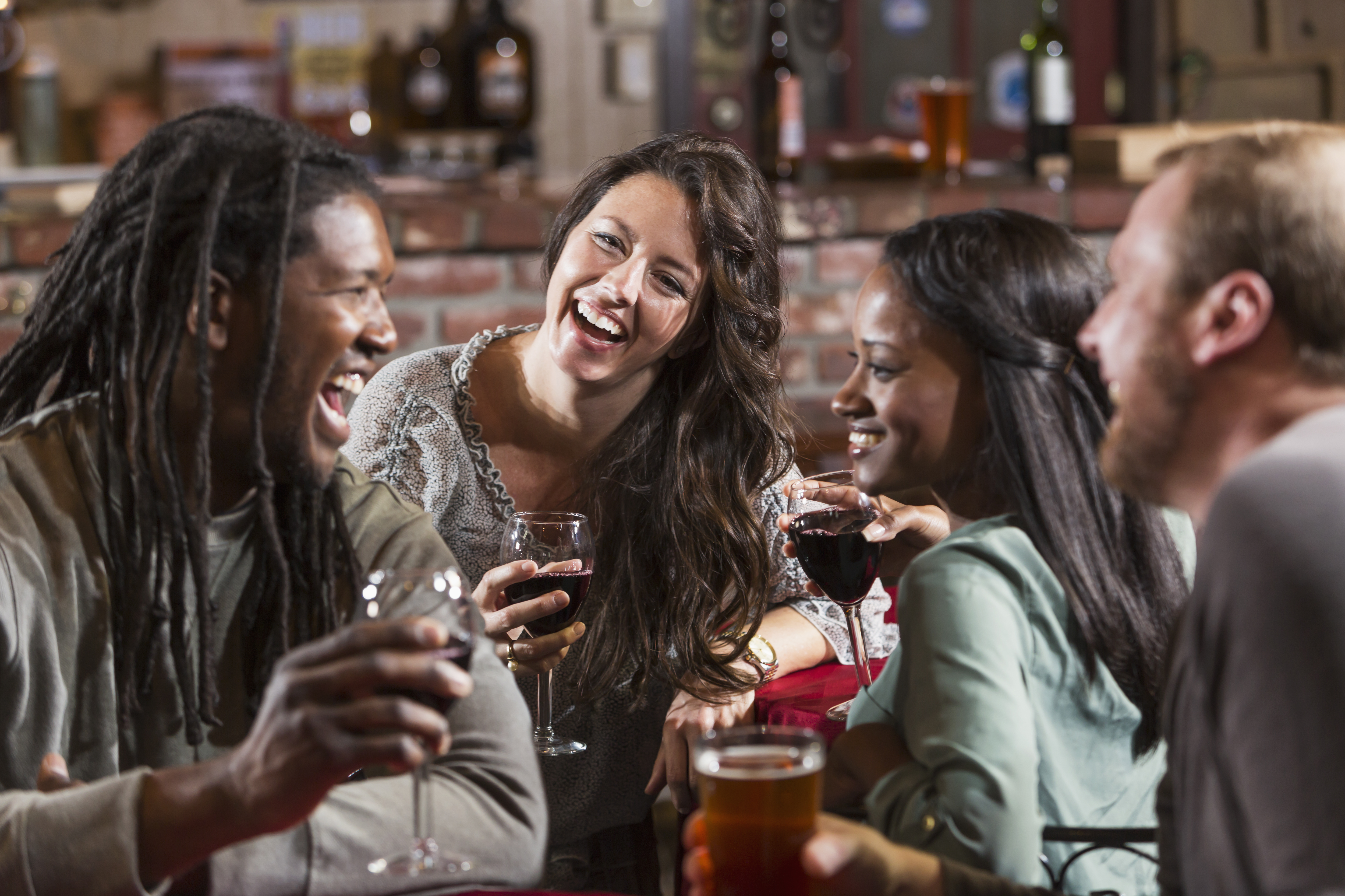 Multiracial group of friends drinking at restaurant bar
