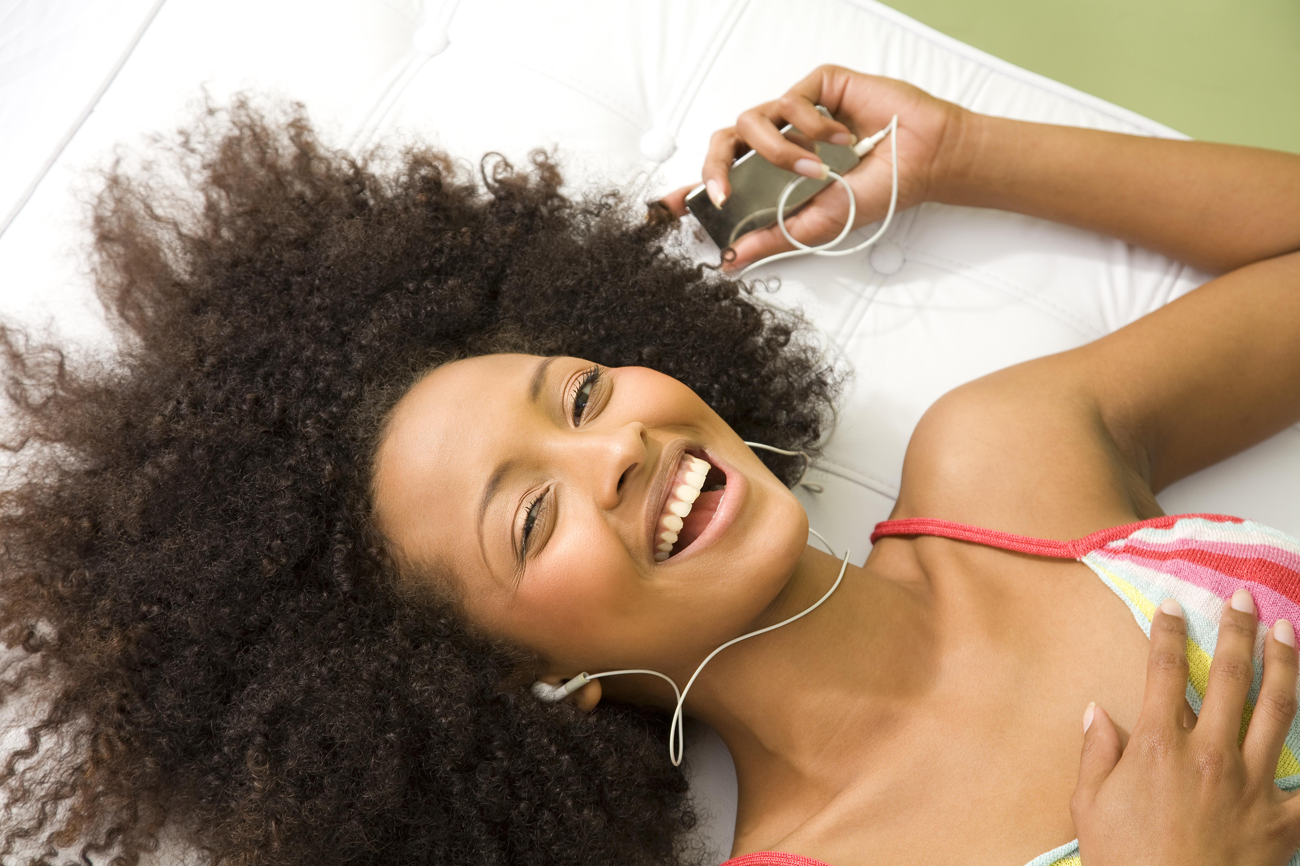 Laughing woman listening to mp3 player