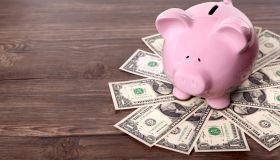 Piggy bank standing on dollars