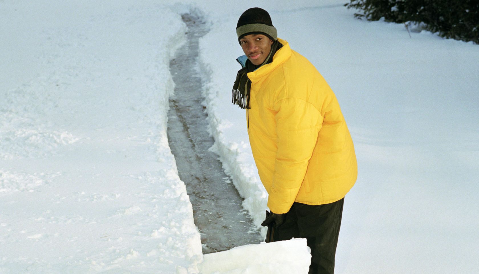 Teenage boy (16-18) shoveling path through snow, elevated view