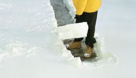 Teenage boy (16-18) shoveling path through snow, elevated view