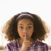 Mixed race girl making shhh gesture