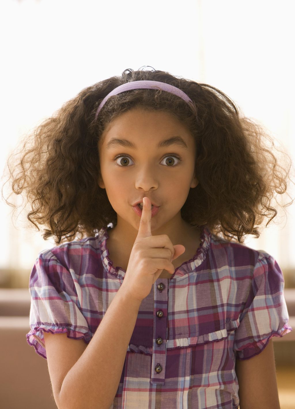 Mixed race girl making shhh gesture