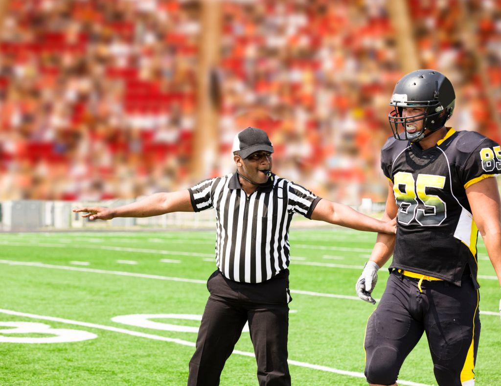 American football referee signals a play during the game. Player.