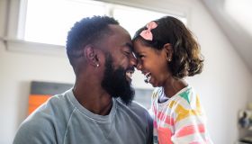 Father and daughter laughing in bedroom - stock photo