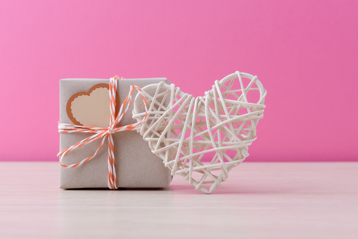 Craft handmade gift box and valentineâs heart over pink background with copy space