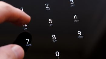 Man's hand finger entering the 4 digit PIN number on a touch screen display unlocking a generic smartphone app on a tablet, mobile phone. Macro detail, extreme closeup, one person password security