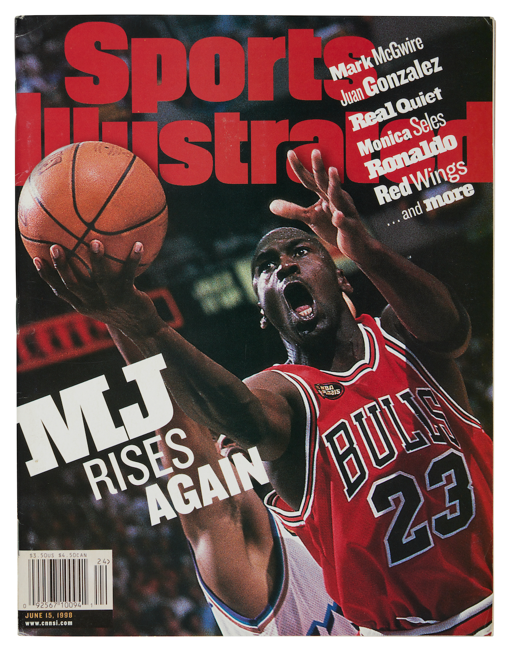 A basketball player in a red jersey with the number 23 jumping up to shoot a basketball, with the Sports Illustrated magazine cover text "M.J. RISES AGAIN" visible.
