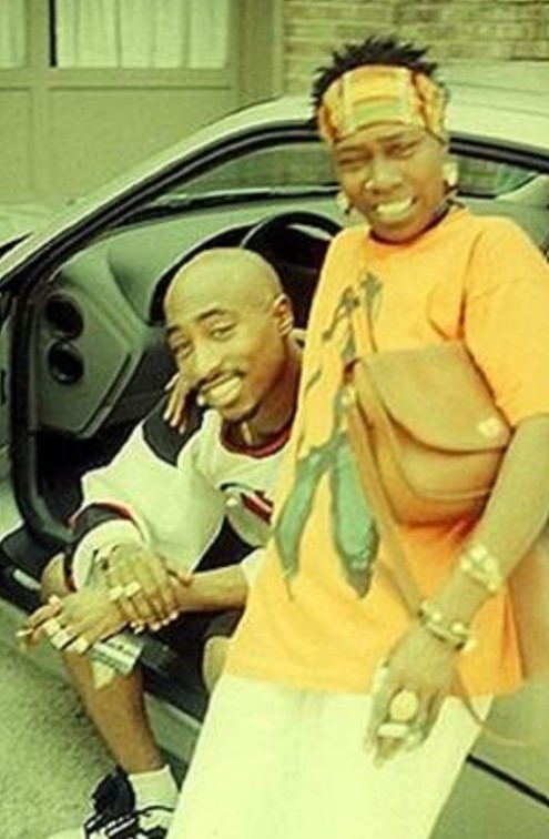 Two smiling men in yellow shirts sitting in a car